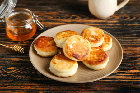 Plate with tasty cottage cheese pancakes on tableの写真素材