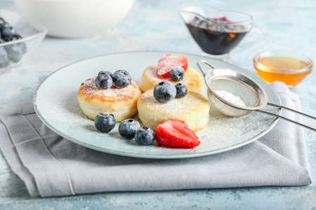 Plate with tasty cottage cheese pancakes and berries on tableの写真素材