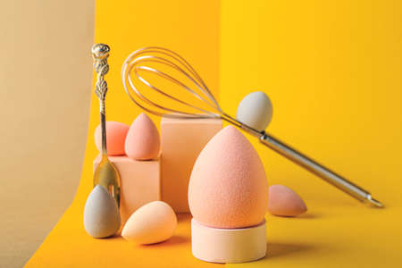 Creative composition with makeup sponges, fork and whisk on color background, closeupの写真素材