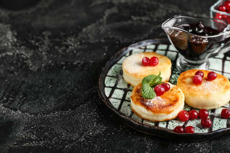 Plate with tasty cottage cheese pancakes. cranberry and jam on dark backgroundの写真素材
