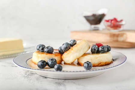 Plate with tasty cottage cheese pancakes and berries on table