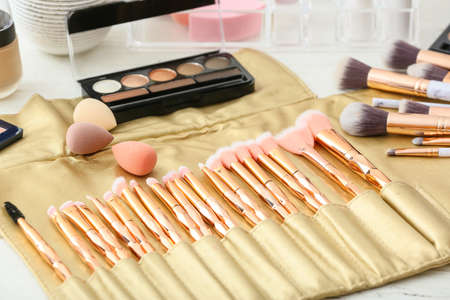 Set of makeup brushes and decorative cosmetics on dressing table