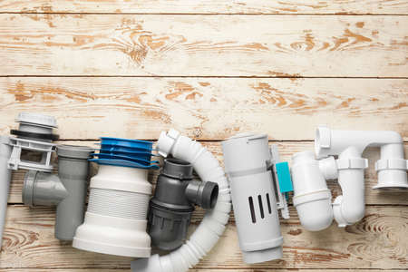 Set of plumber's items on light wooden backgroundの写真素材