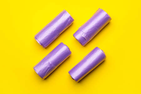 Rolls of garbage bags on color background