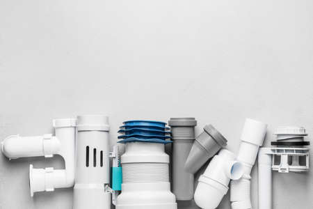 Set of plumber's items on light background