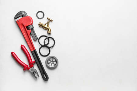 Set of plumber's items on light background