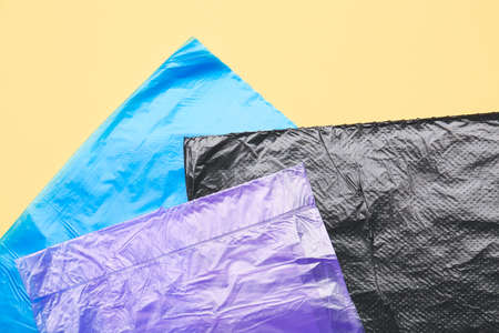 Garbage bags on color background