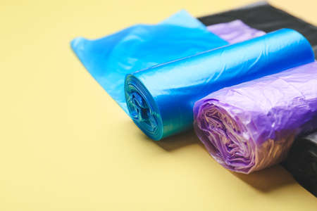 Rolls of garbage bags on color background