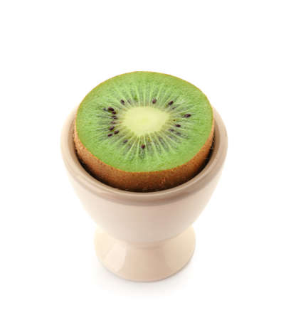 Egg holder with half of ripe kiwi on white backgroundの写真素材