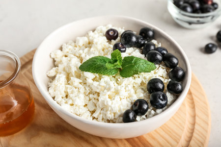 Bowl of cottage cheese with blueberries on light backgroundの写真素材