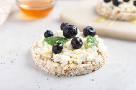 Crispbread with cottage cheese and blueberries on light backgroundの写真素材
