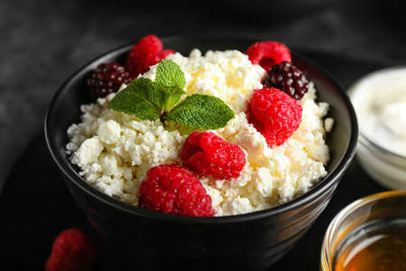 Bowl of cottage cheese with raspberries on dark backgroundの写真素材