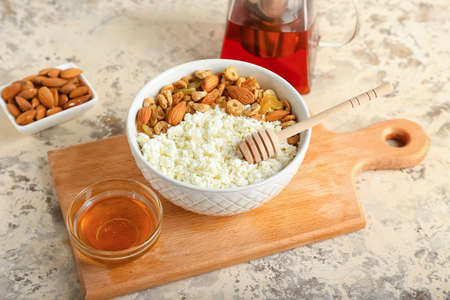 Bowl of cottage cheese with peanuts and cereals on light backgroundの写真素材