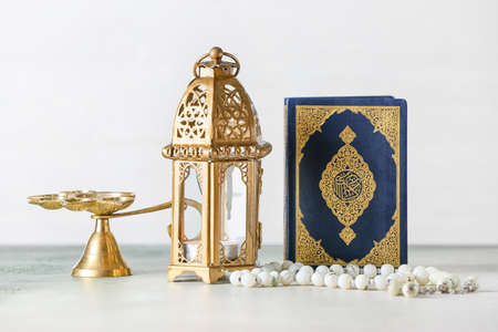 Muslim lamp, tasbih and Koran on light backgroundの写真素材