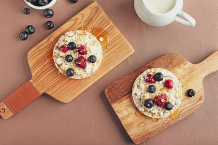Crispbreads with cottage cheese and berries on color backgroundの写真素材