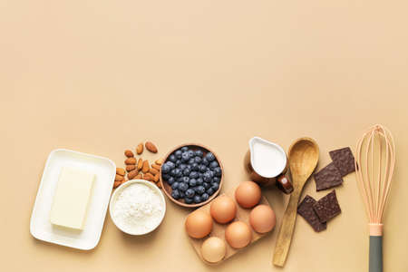 Ingredients for preparing bakery and kitchen utensils on color background