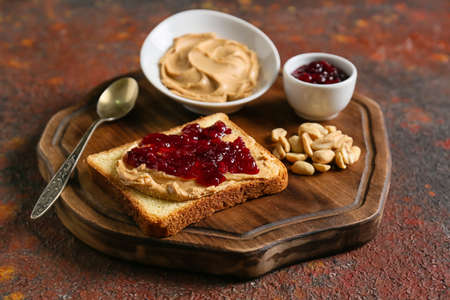 Toast with tasty peanut butter and jam on grunge backgroundの写真素材
