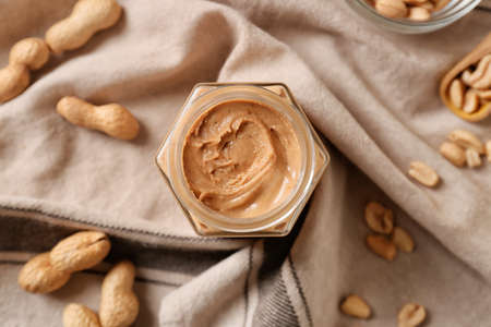 Jar with tasty peanut butter on fabric backgroundの写真素材