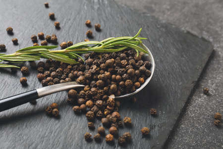 Spoon with peppercorns on dark backgroundの写真素材