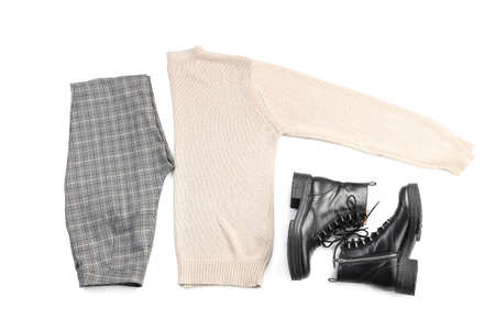 Stylish trousers, sweater and leather boots on white background