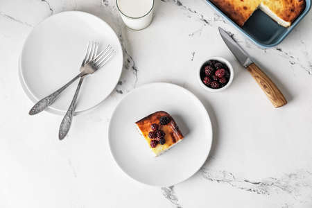 Plate with piece of cottage cheese casserole on light backgroundの写真素材