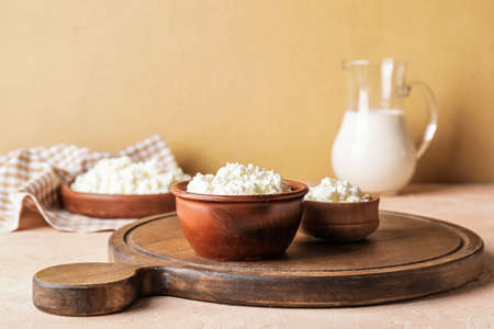 Bowls with cottage cheese on color backgroundの写真素材