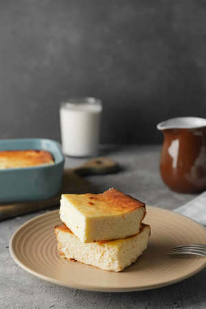 Plate with pieces of cottage cheese casserole on table