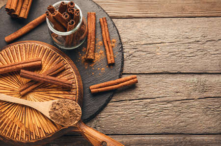 Cinnamon sticks and powder on wooden background