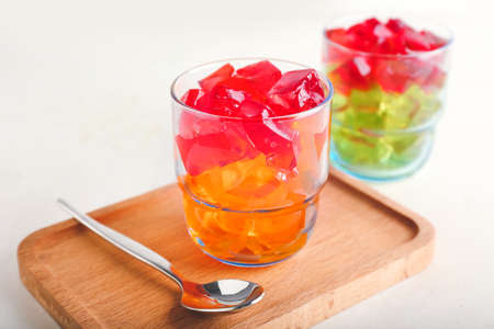 Glass with tasty jelly cubes on tableの写真素材