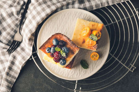 Plate with pieces of cottage cheese casserole on dark background