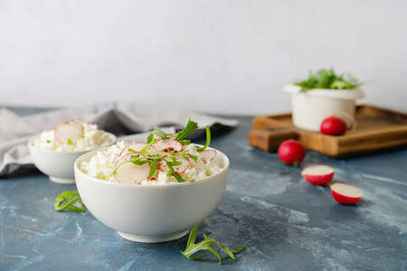 Bowls with cottage cheese on color backgroundの写真素材