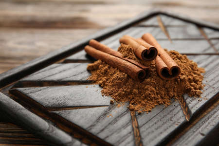 Cinnamon sticks and powder on wooden backgroundの写真素材