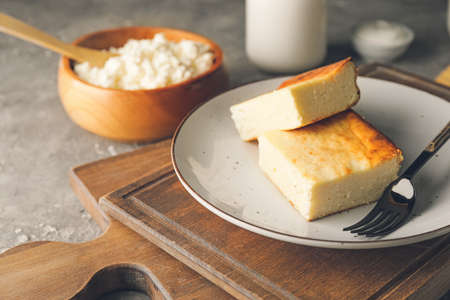 Plate with pieces of cottage cheese casserole on grunge backgroundの写真素材