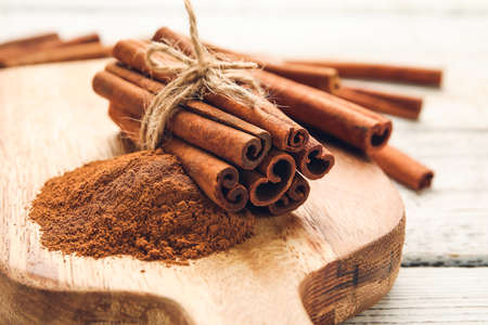 Cinnamon sticks and powder on wooden backgroundの写真素材
