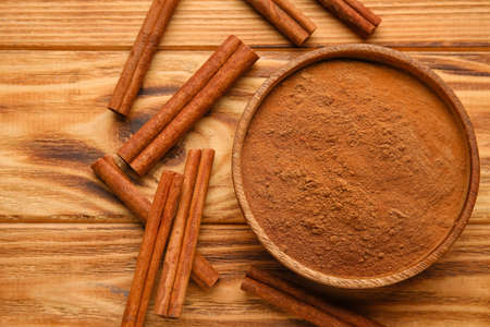 Cinnamon sticks and powder on wooden backgroundの写真素材