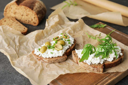 Tasty sandwiches with cottage cheese and olives on tableの写真素材