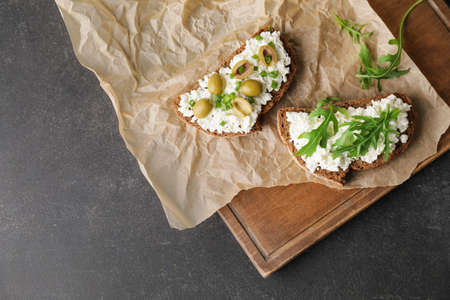Tasty sandwiches with cottage cheese and olives on dark backgroundの写真素材