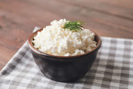 Bowl with cottage cheese on wooden backgroundの写真素材