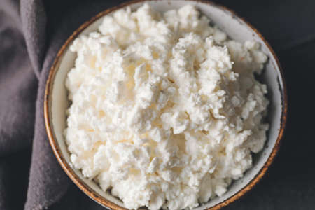 Bowl with cottage cheese on dark background, closeupの写真素材