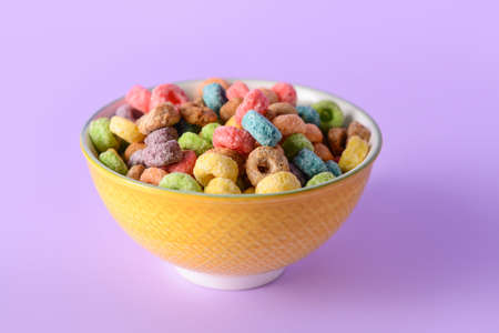 Bowl with crunchy corn flakes rings on color backgroundの写真素材