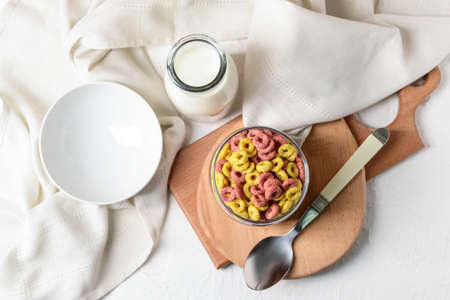 Crunchy corn flakes rings with bottle of milk on white backgroundの写真素材