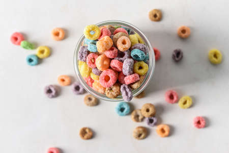 Glass with crunchy corn flakes rings on light backgroundの写真素材