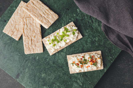 Crispbreads with cottage cheese on dark backgroundの写真素材