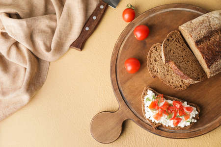 Tasty sandwich with cottage cheese and tomatoes on color backgroundの写真素材