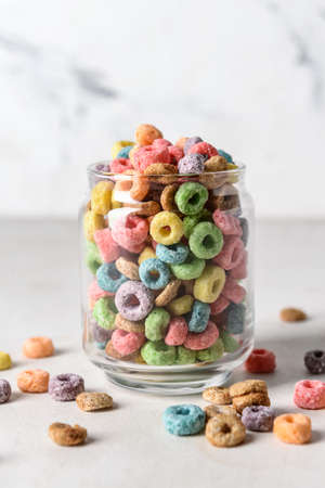 Glass with crunchy corn flakes rings on light backgroundの写真素材