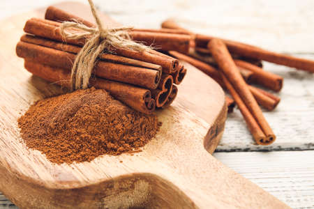 Cinnamon sticks and powder on wooden backgroundの写真素材