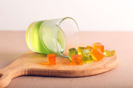 Glass with tasty jelly cubes on tableの写真素材