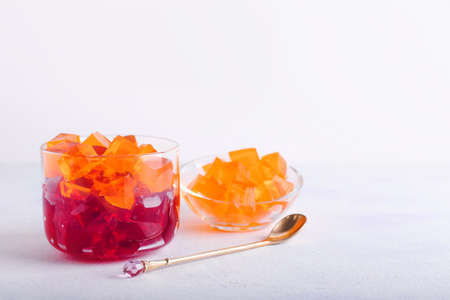 Glass bowl with tasty jelly cubes on white backgroundの写真素材