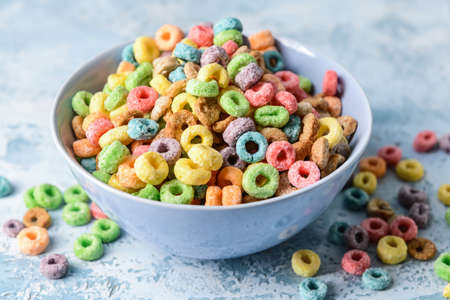 Bowl with crunchy corn flakes rings on color backgroundの写真素材