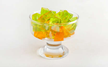 Glass bowl with tasty jelly cubes on white backgroundの写真素材